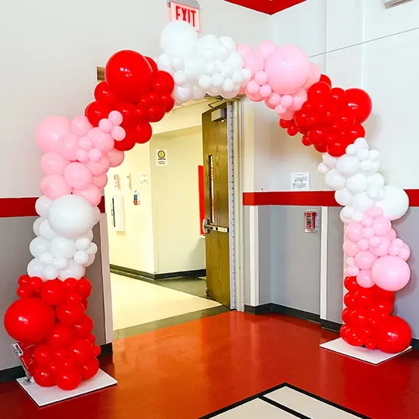 Red, white and pink balloon arch framing a doorway