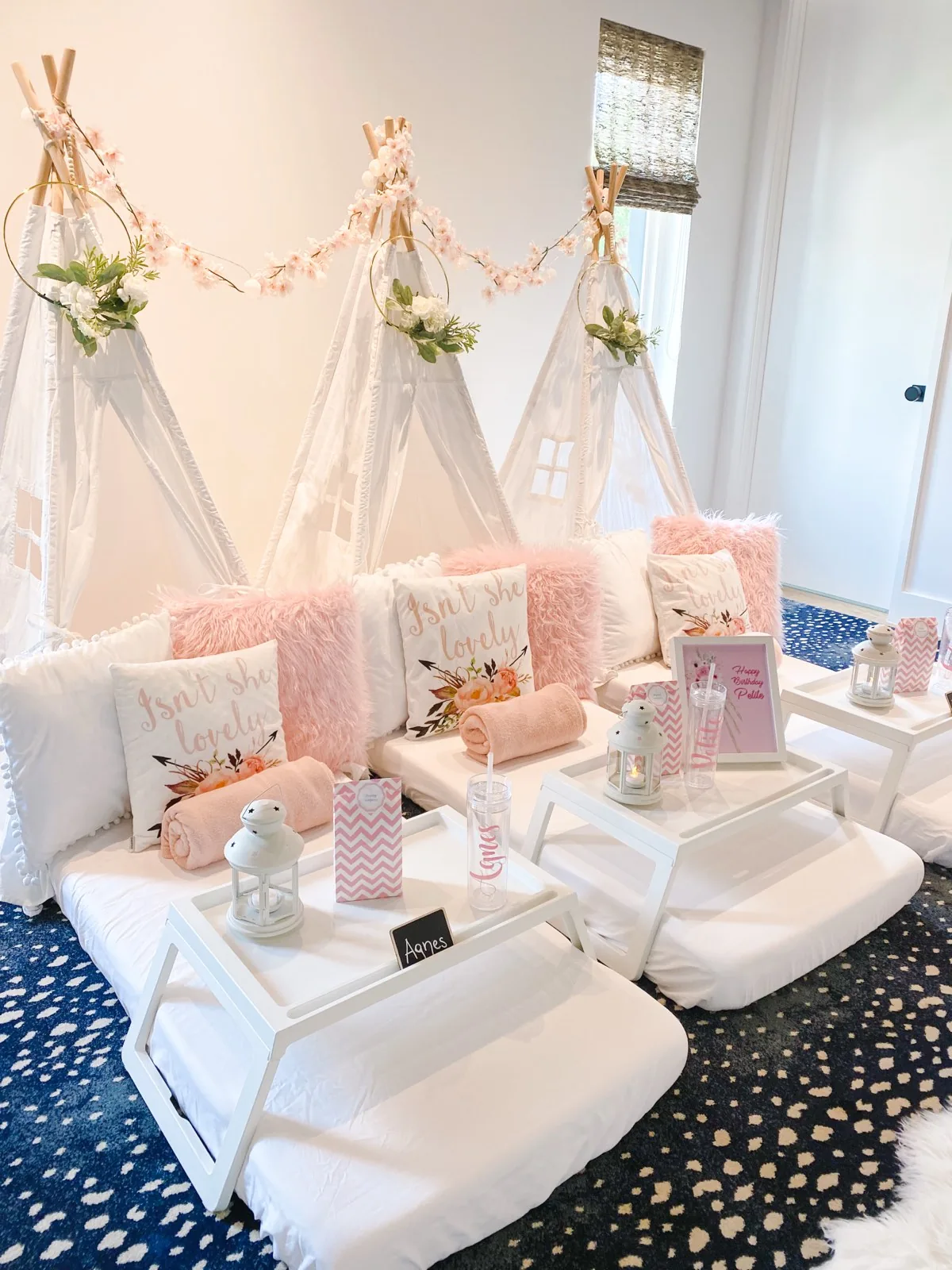Luxury teepee sleepover styled in blush with a cherry blossom garland