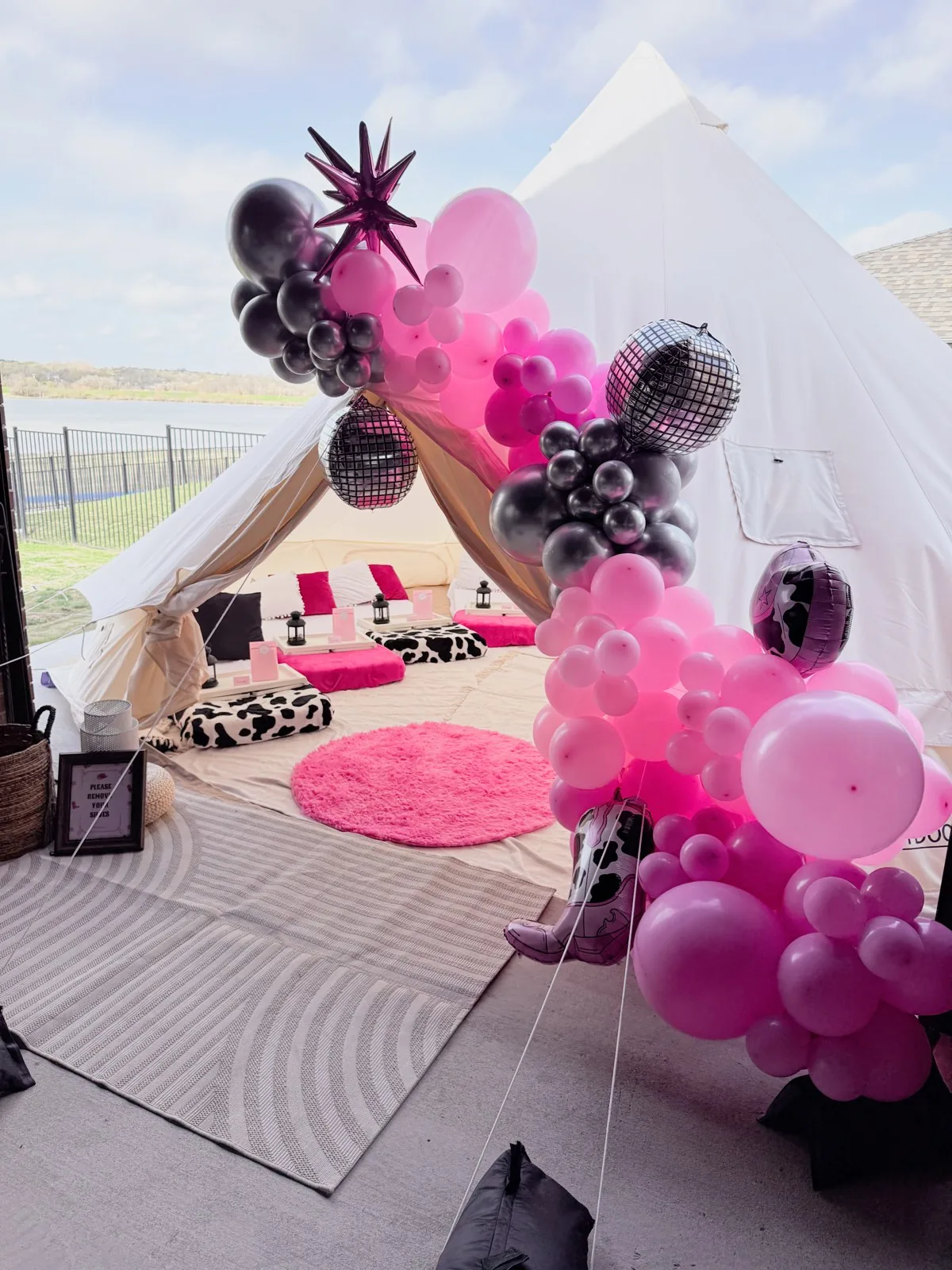 Luxury bell tent glamping party with a pink balloon garland